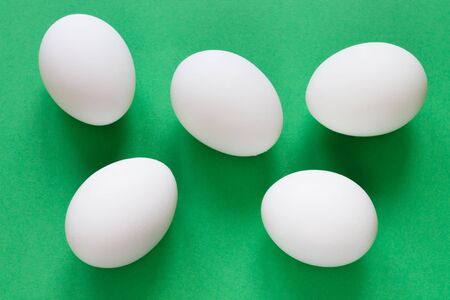 Five white eggs lie on a luscious green background. Closeupの写真素材