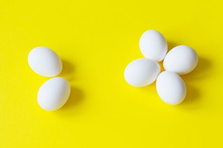 Six white eggs lie on a colorful yellow background. Good morning concept