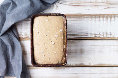 Raw rye and wheat bread on flour sourdough in the form, on a light wooden background. Copy spaceの写真素材