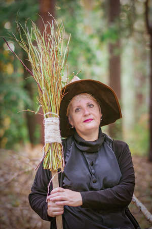 Portrait of an elderly witch in a hat, with a broomの写真素材