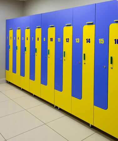 classic locker room with blue and yellow rows of lockers.