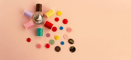 Accessories for needlework on a plain background. Spools of thread, buttons, tape measure, sewing...