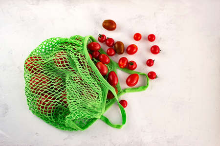 Flat lay Fresh tomato in eco Reusable shopping bag with net without waste on white backgroundの写真素材