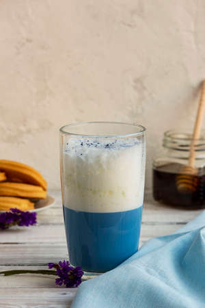 Blue matcha tea in a glass of latte on the table. Place for text.Vertical orientation. Selective focus.の写真素材