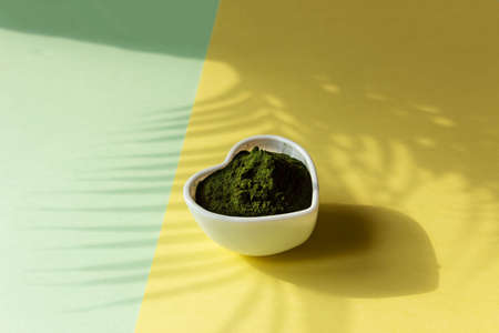 Organic spirulina pills in a heart shaped plate.の写真素材