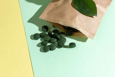 Organic spirulina pills flying out of paper bag, space for text, space for textの写真素材
