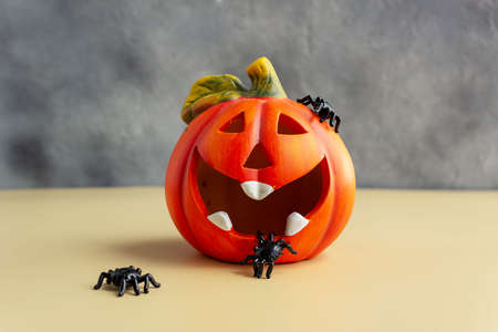 Halloween pumpkin and black spiders, holiday card. Horizontal photo, place for text.の写真素材