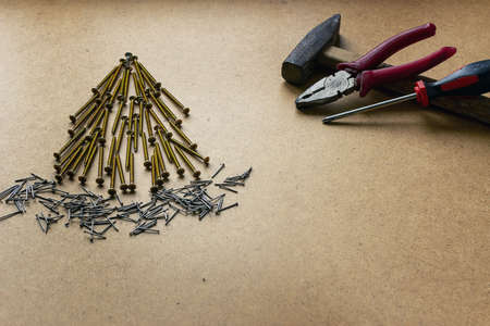 Spruce from self-tapping screws on a wooden background. Christmas renovation theme with place for...