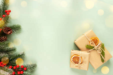 Fir branch and gifts on a green background, top view. Christmas and New Years concept. Place for...
