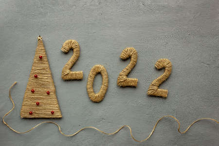 Numbers 2022 and do-it-yourself spruce made of cardboard and linen rope. The concept of preparing...