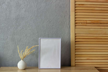 Home decor mockup, blank photo frame near gray painted concrete wall. Place for your text.