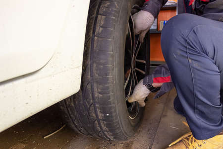 Auto mechanic in the process of replacing new tires. Repair of car brakes in the garage. Car service...