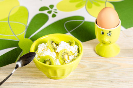 Breakfast for child: boiled egg and curd cheese with kiwiの写真素材