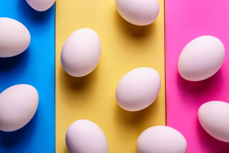 Minimalism style.  Flat lay image eggs in a raw, on colored pastel  background.の写真素材