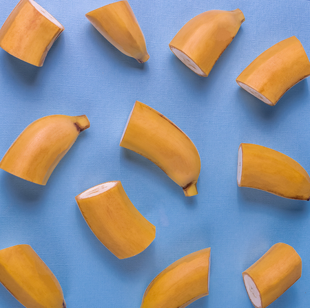 Creative concept. Flat lay view of banana fruit pattern over blue background.の写真素材