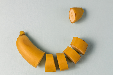 Creative concept. Flat lay view of cutted banana fruit over light background.の写真素材
