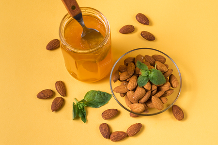 Flay lay view of Homemade jam in a glass jar and chestnuts against yellow background.の写真素材