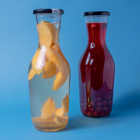 Two glass Jars of cherry and quince compote isolated on blue.の写真素材