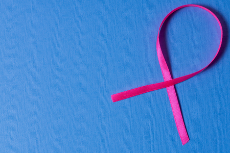 pink ribbon breast cancer awarerness on blue background with copy spaceの写真素材