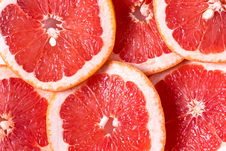 Healthy eating concept. Pattern with fresh slices of grapefruit. Flat lay.の写真素材