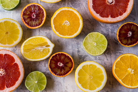 Healthy eating concept. Pattern with fresh slices of different Citrus fruit - yellow and red orange, lemon and lime. Flat lay.の写真素材