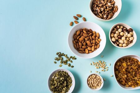 Top view the set of Superfoods and nuts in Bowls on blue Background with copy space.の写真素材
