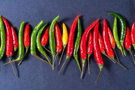 Top view the red , green and yellow chili peppers pattern over gray background, flat lay.の写真素材