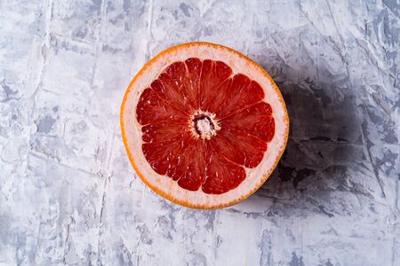 Healthy eating concept. Flat lay view raw fresh red orange fruit over gray background and copy space.の写真素材