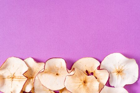 Flat lay Dried apple chips over purple background with copy space.の写真素材