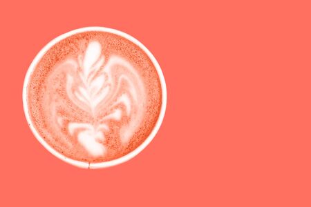 Flat lay Latter art coffee in a paper cup painted to color of the year 2019 - living coral color.
