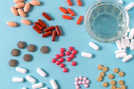 Medical concept. White and yellow medicine pills over blue background.