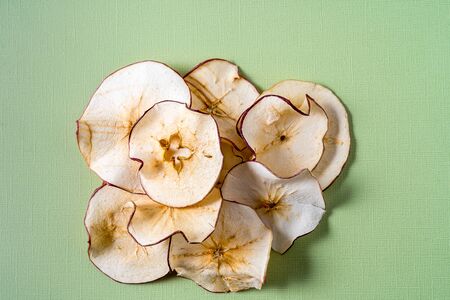 Flat lay Dried apple chips over green background with copy space.の写真素材