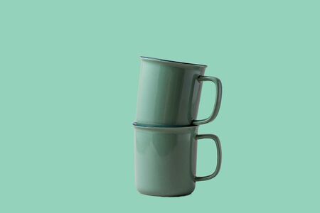 Two mugs for Coffee or tea of trendy neo mint color, over neo mint background, copy space for text.の写真素材