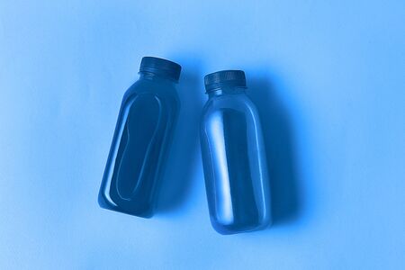 Minimal style. Classic Blue color of the Year 2020. The healthy drink in Eco bottles toned in classic blue color of the year 2020 over trendy classic blue color background.の写真素材