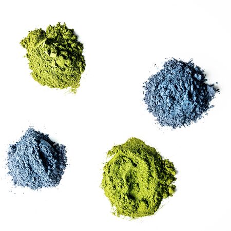 Heaps of matcha green and blue tea powder isolated on white background, view from above.の写真素材
