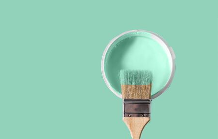 The brush in the paint color of neo mint and the can with paint color neo mint over neo mint background. Copy space text.の写真素材
