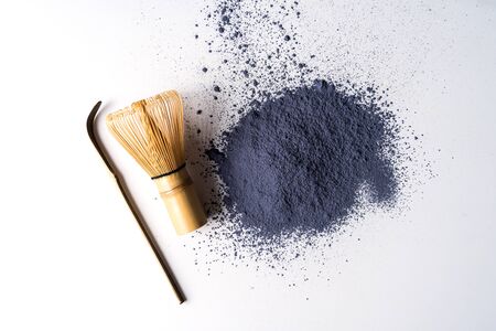 Heap of matcha blue tea powder and bamboo chasen isolated on white background, view from above.の写真素材