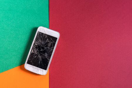 Flat lay Broken mobile phone with black cracked display on colorful background.の写真素材