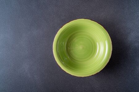 Flat lay Empty green plate over black wooden table, copy space for text.の写真素材