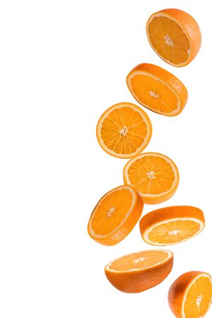 Flying fruits. Falling sliced orange fruit isolated on white background to use in design.の写真素材
