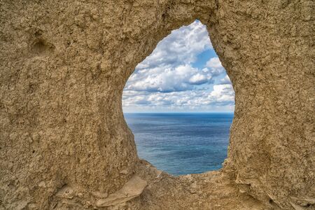 View through the round rock with swallow's nests to the Black sea, in Anapa, Russia,toned image.の写真素材