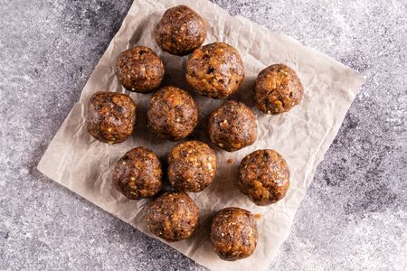 Energy balls with dried fruits and nuts on gray concrete background. Healthy vegan food concept....
