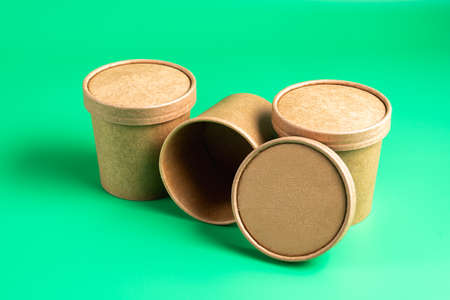 Empty paper disposable cup fo takeaway food container isolated on green background.
