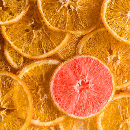 Dried orange yellow fruit chips and one red chip, top view.の写真素材