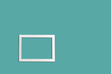 Minimalistic style. A white blank picture frame on an neo mint background, flat lay.の写真素材