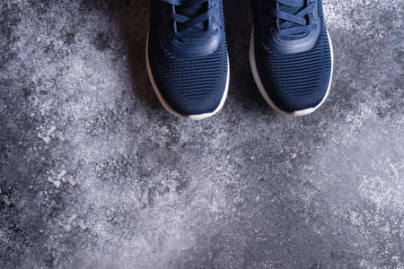 Fitness equipment with sneakers on gray conbcrete background, top view, copy space for text.の写真素材