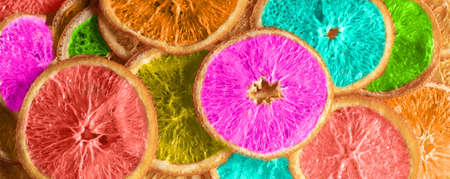 Dried orange fruit chips toned in different color, abstract, top view.の写真素材