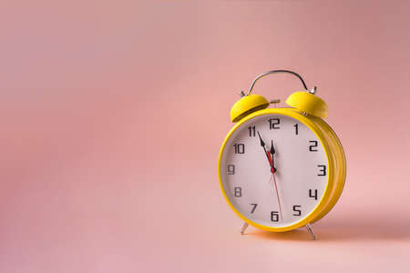 Yellow Retro style yellow alarm clock on pink background, copy space for text.の写真素材