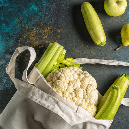 Flat lay Fresh vegetables into the eco Reusable zero waste textile shopping bag over white background, horizontal.の写真素材