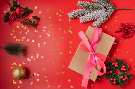 Festive Christmas and new year decorations with gift box, balls, cones and toys on red background.の写真素材